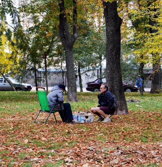 Groupe d'adultes autour d'une partie d'échecs Groupe d'adultes réunis autour d'une partie d'échecs – animation échecs en entreprise